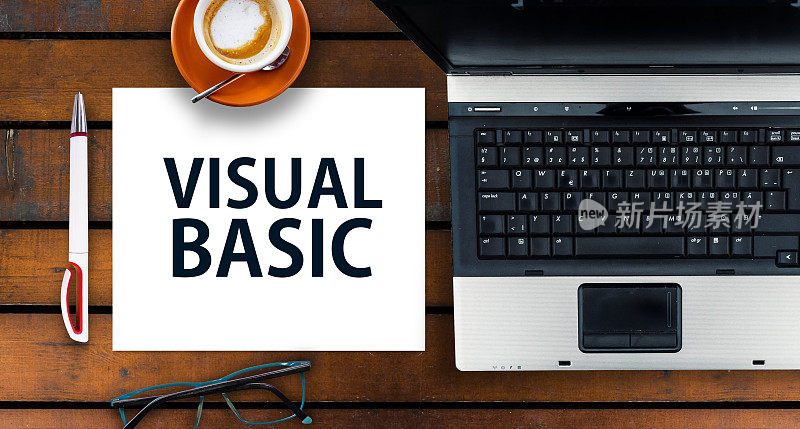 纸宽字Visual Basic和笔记本电脑，眼镜和咖啡在木桌上